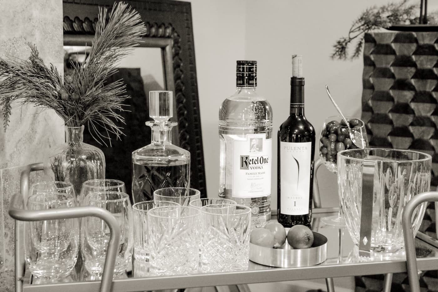 A home bar cart stocked with bottles and glassware