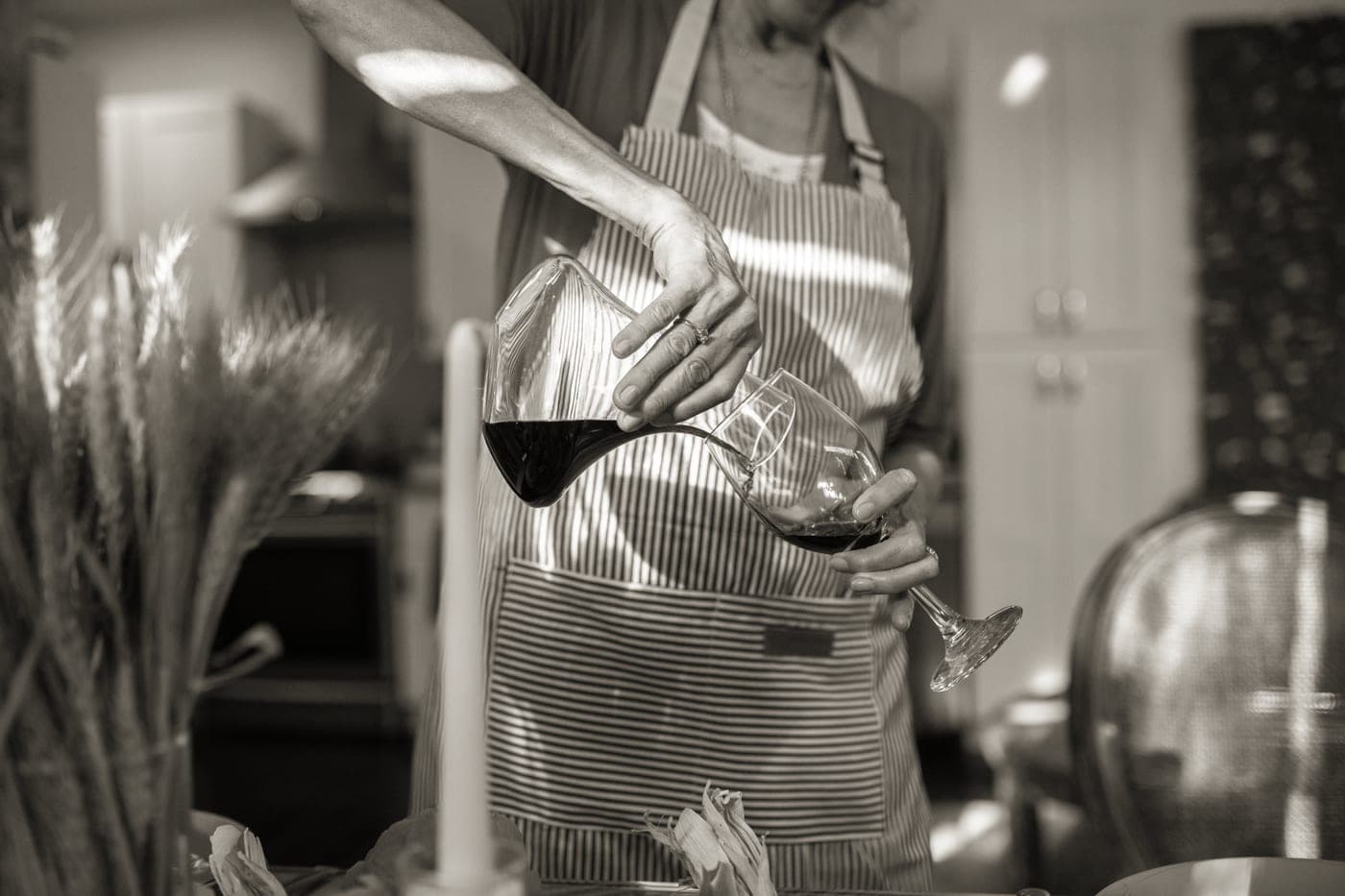 Red wine being poured from a glass decanter