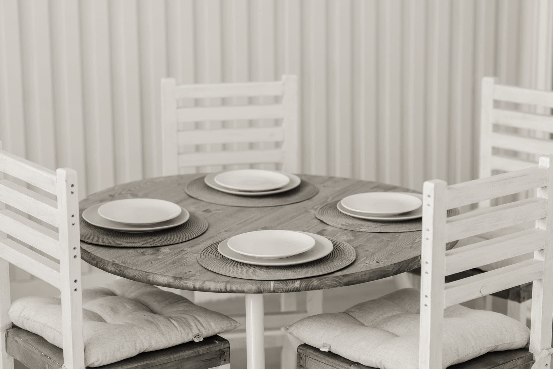 Four ceramic place settings laid out on a dining table