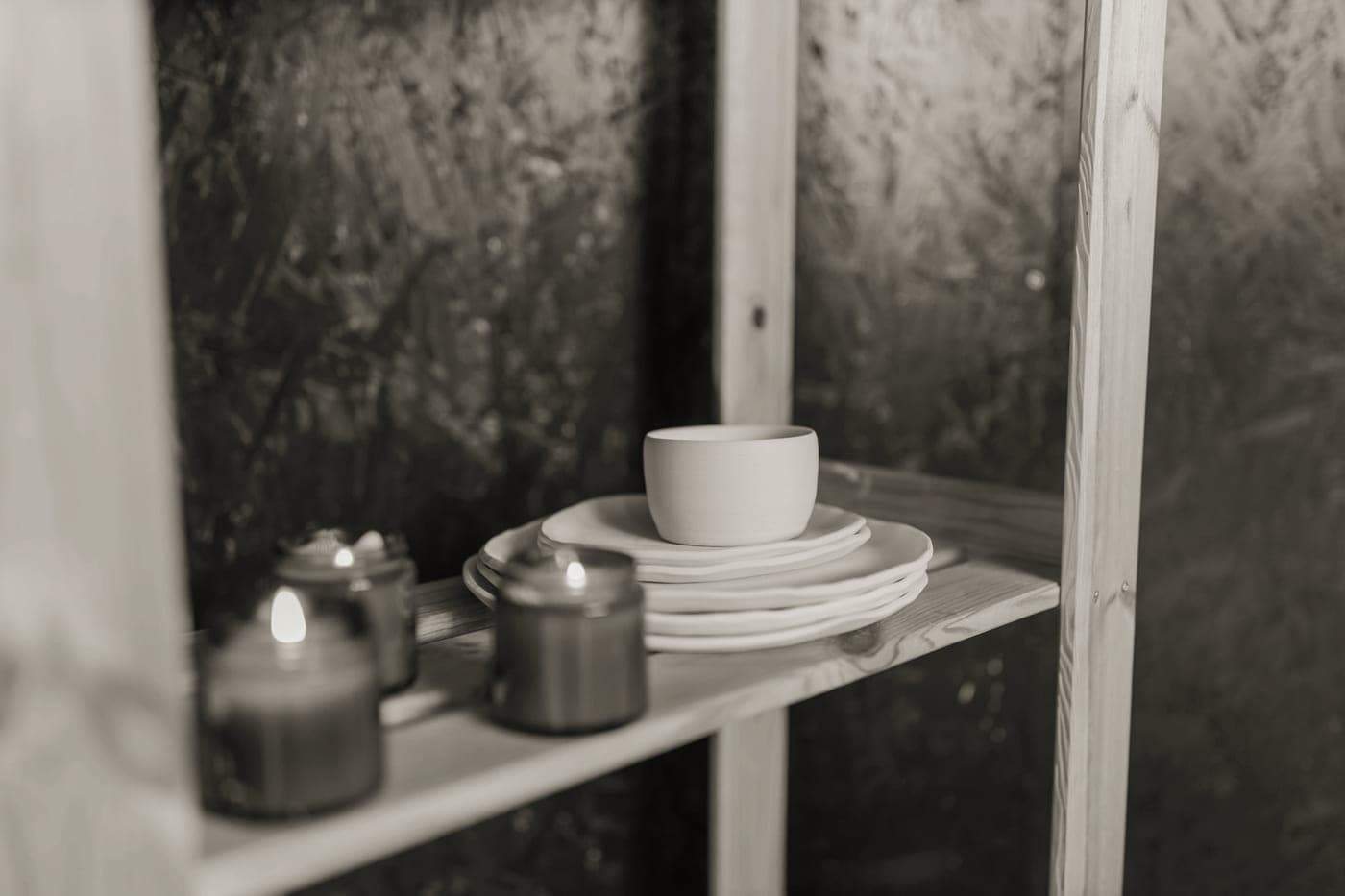 Everyday ceramic plates stacked on an open kitchen shelf