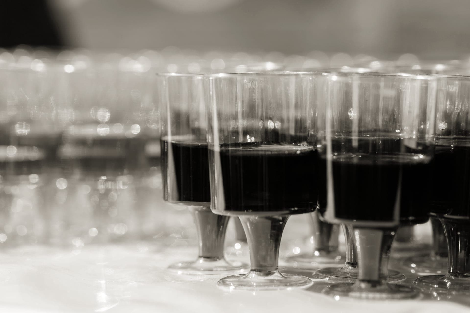 A row of wine glasses set out on a party table