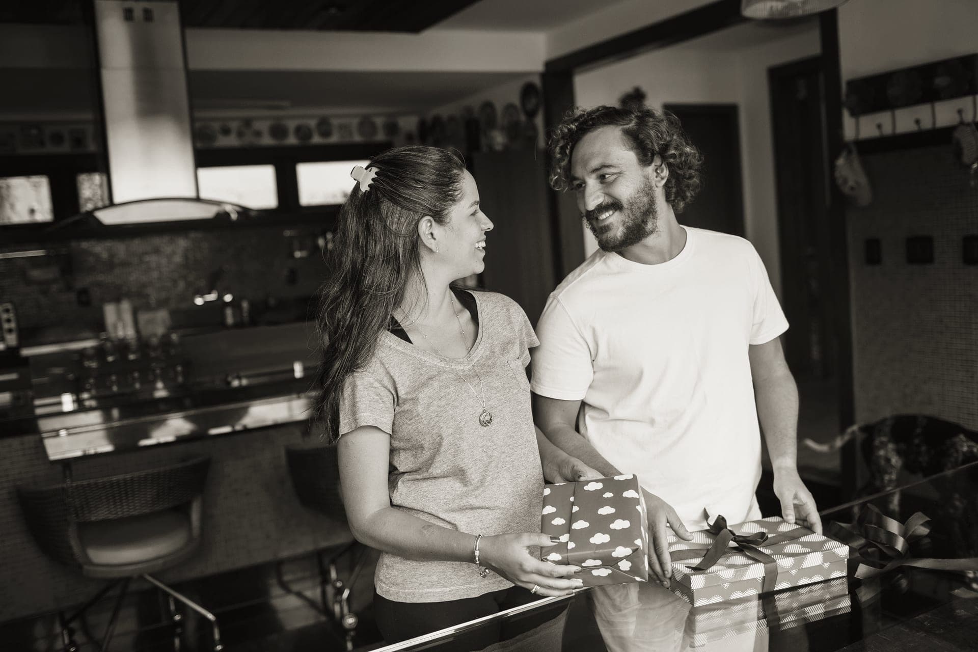 A couple with a wrapped gift in the kitchen of a new home