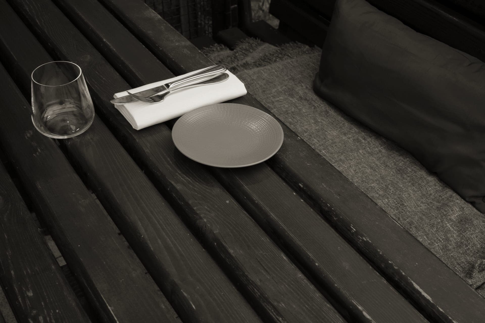 Plates and bowls set out on an outdoor table for a meal