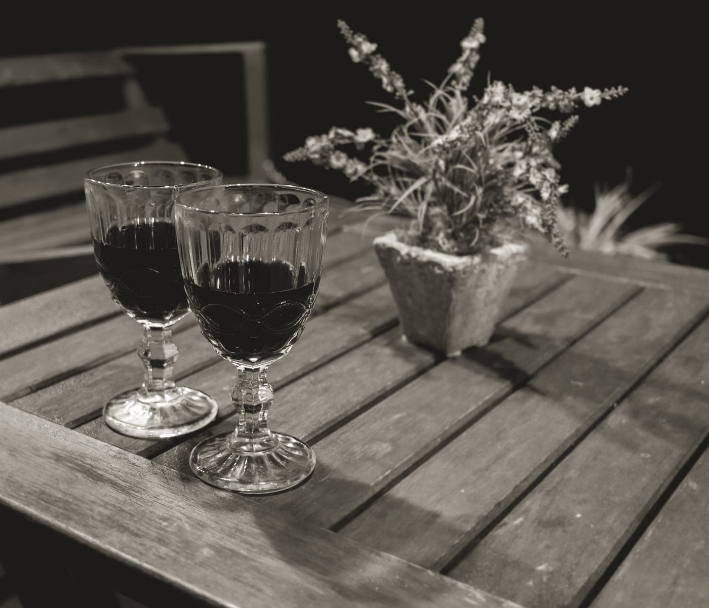 Wine glasses on a wooden table with red wine poured